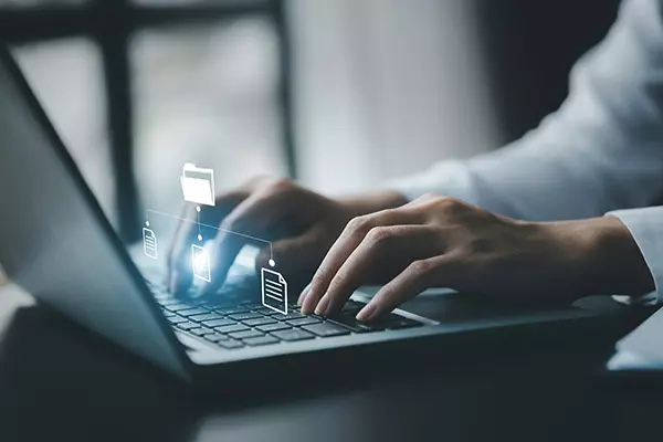 homme d'affaires tapant sur un clavier avec des hologrammes de fichiers de documents numériques
